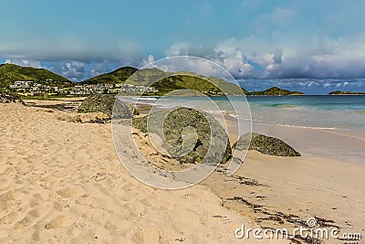 A view past large boulders along Orient beach in St Martin Stock Photo