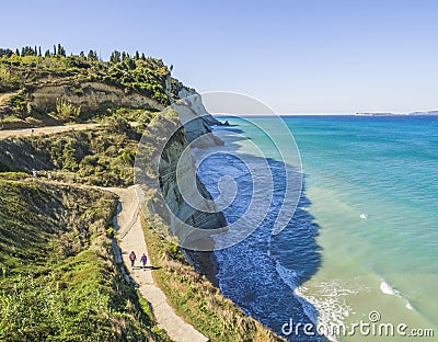 View from Peroulades view point on of white rock steep cliff volcanic bay of Cape Drastis and Peroulades area with Stock Photo