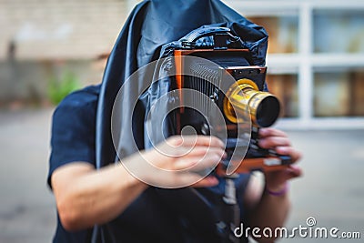 View of a photographer with an old-style vintage retro camera, old fashioned photo camera, man shooting photography in old style Stock Photo