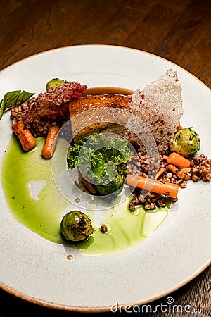 view on plate with dish of piece of baked pork meat with buckwheat and vegetables Stock Photo