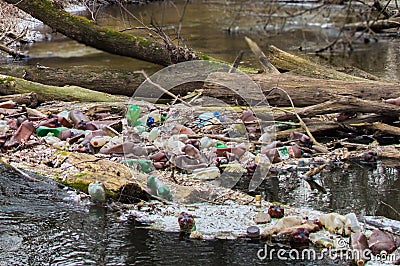 View of the polluted small forest river with a lot of different plastic garbage. Environment pollution problem Stock Photo