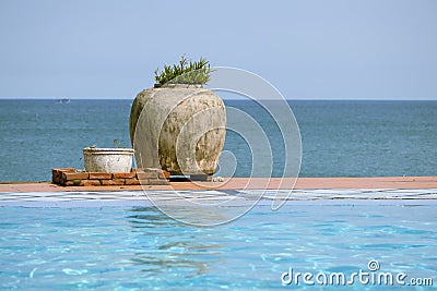 View with pool by the sea and the large stone vase with the plant Stock Photo