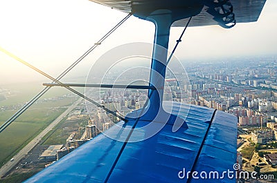 View in the porthole airplane of a turboprop aircraft biplane on the city streets and houses. Stock Photo