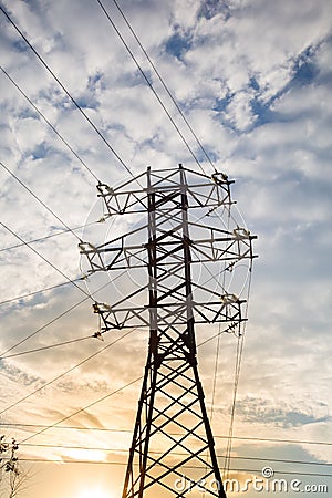 View of the power line against the clouds of blue sky in the sunlight. Stock Photo