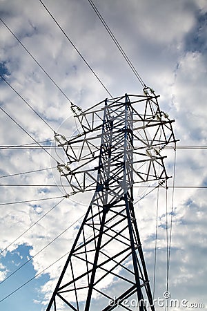 View of the power line against the clouds of blue sky in the sunlight. Electric, technology. Stock Photo