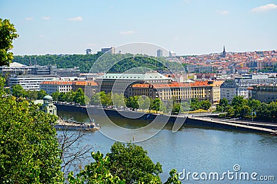 View of Prague with river Vltava with ships and amazing buildings with red roofs. Editorial Stock Photo