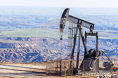 View of the pumpjack in the oil well of the oil field. Arrangement is commonly used for onshore. Stock Photo