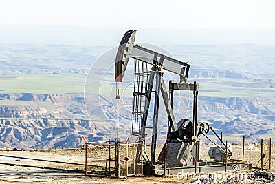 View of the pumpjack or piston pump in the oil well oil field. Modern pumpjacks are powered by a prime mover. Stock Photo