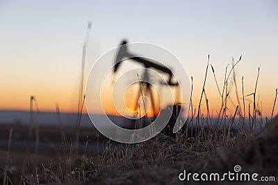 View of Pumpjack at Sunset from Petroleum Area Stock Photo