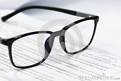 Reading glasses on the paper sheet. Stock Photo