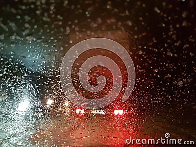 View of the rear of the truck stopped through the windshield with drops of melted snow. Winter night Stock Photo