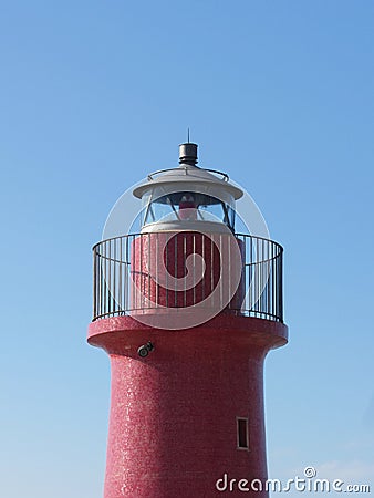A view of the red harbor lighthouse along the Tuscany coastline in Castiglione della Pescaia, Italy Stock Photo
