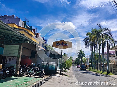 The view of the restaurant on a quiet roadside with a clear sky background. street photography palembang Editorial Stock Photo