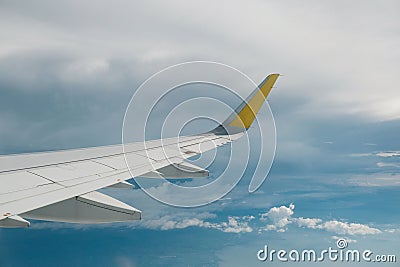View of right wing from window of airplane flying up in the sky, through clouds in atmosphere. Plane in flight. Up in the air. Stock Photo