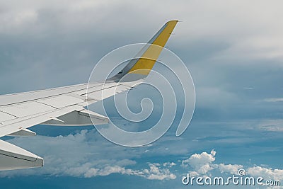 View of right wing from window of airplane flying up in the sky, through clouds in atmosphere. Plane in flight. Up in the air. Stock Photo