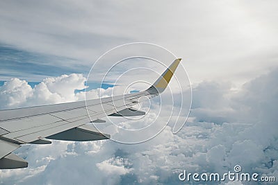 View of right wing from window of airplane flying up in the sky, through clouds in atmosphere. Plane in flight. Up in the air. Stock Photo