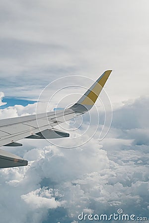 View of right wing from window of airplane flying up in the sky, through clouds in atmosphere. Plane in flight. Up in the air. Stock Photo