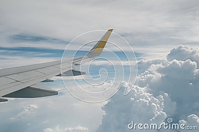 View of right wing from window of airplane flying up in the sky, through clouds in atmosphere. Plane in flight. Up in the air. Stock Photo