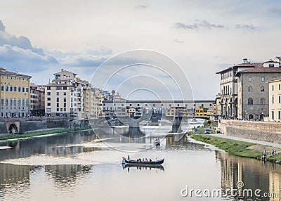 View of the river Arno, Ponte Vecchio bridge and pleasure boats in Florence in the evening Editorial Stock Photo