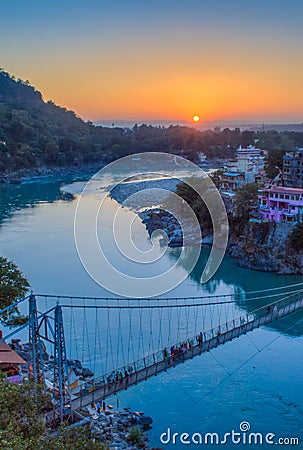 View of River Ganga and Lakshman Jhula bridge at sunset. Rishikesh. India Stock Photo