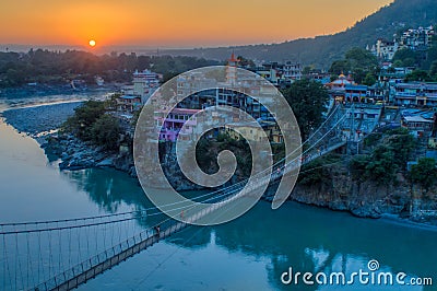 View of River Ganga and Lakshman Jhula bridge at sunset. Rishikesh. India Stock Photo