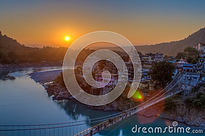 View of River Ganga and Lakshman Jhula bridge at sunset. Rishikesh. India Stock Photo