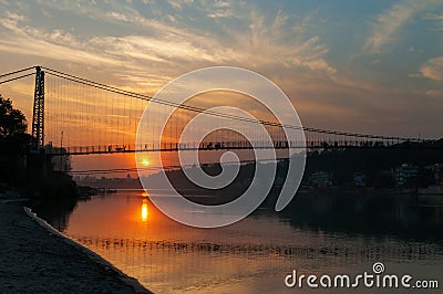 View of River Ganga and Ram Jhula bridge at sunset Stock Photo