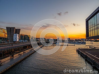 View of a river and modern buildings during scenic sunset, Amsterdam Stock Photo