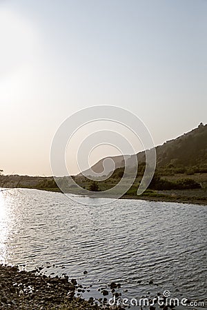 View of the river and the mountain during the beginning of the sunset Stock Photo