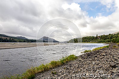 A view of River Pattack flowing to the head of Loch Laggan and Scottish highlands on the background, Cairngorms National park, Sco Stock Photo