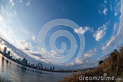 View of riverside with a blue sky, some plants and Umeda city in the background Editorial Stock Photo