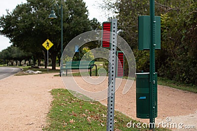 View of a road by the park with roadsigns and a bench Stock Photo