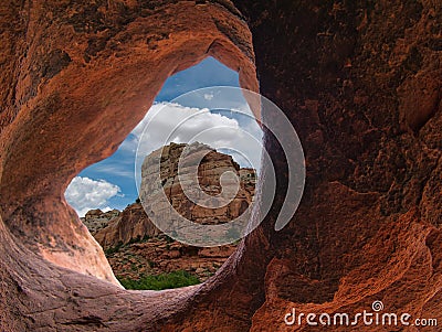 View through a rock hole to a rocky mountain Stock Photo