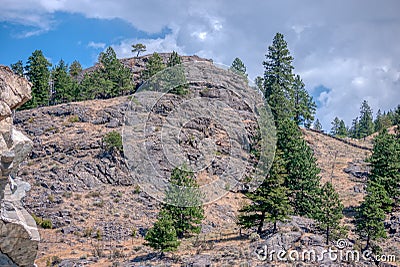 View at rocky mountain slop on cloudy sky background Stock Photo