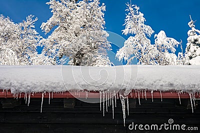 View of a roof with heavy snow and icicles Stock Photo