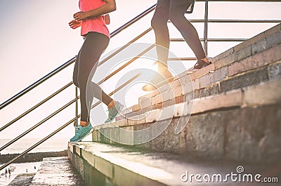 View of runners legs having a workout session on city stairs outdoor - Close up of people running at sunset Stock Photo