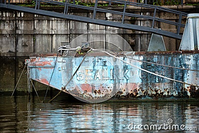 View of a rusty old barge moored to the docks Editorial Stock Photo