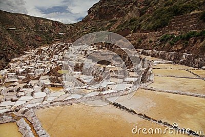 View of Salt ponds, Maras, Peru, South America with cloudy blue sky Stock Photo