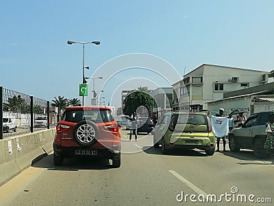 View of samba road in the Luanda city downtown center with road, vehicles, people selling products on road and buildings Editorial Stock Photo