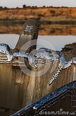 View of the sand pit through the metal teeth of the excavator Stock Photo