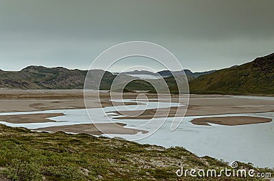 View through the Sandflugtdalen valley over river towards the mountains and Greenlandic icecap, Greenland Stock Photo