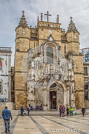 View of the Santa Cruz Monastery front facade, romanesque and gothic style, with tourists on street , a National Monument in Editorial Stock Photo