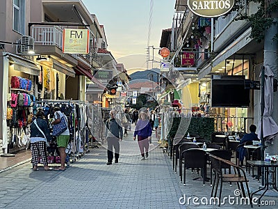 Tourists stroll at night through the streets of Sarti resort located on the Sithonia arm, Halkidiki in Greece Editorial Stock Photo