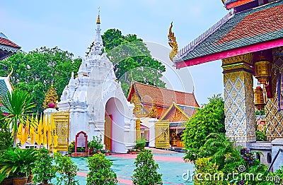 The white gate of Wat Phra That Hariphunchai Temple from its garden, Lamphun, Thailand Stock Photo