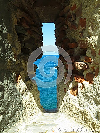 A view of the sea through the loophole of a medieval fort in the southern part of Colliure, France Stock Photo