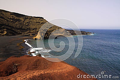 View on secluded lagoon surrounded by impressive rugged weathered cliffs in different colors - El Golfo, Lanzarote Stock Photo