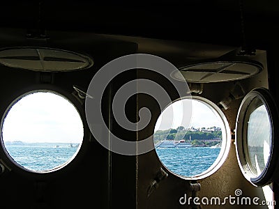 View from the ship cabin through a round porthole, on a green sea island. Sea transport concept. Transportation of people by sea Editorial Stock Photo
