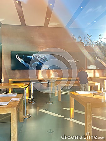 View from the showcase at Empty tables of Apple Store with no customers inside Editorial Stock Photo