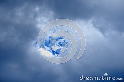 SMALL GAP REVEALING BLUE SKY THROUGH CLOUDS Stock Photo