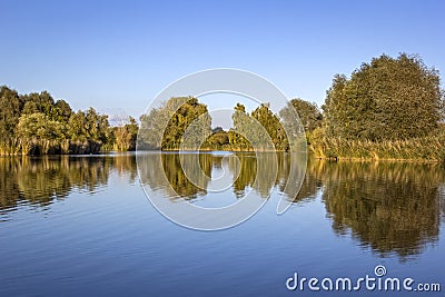 View of a small lake on a windless evening Stock Photo